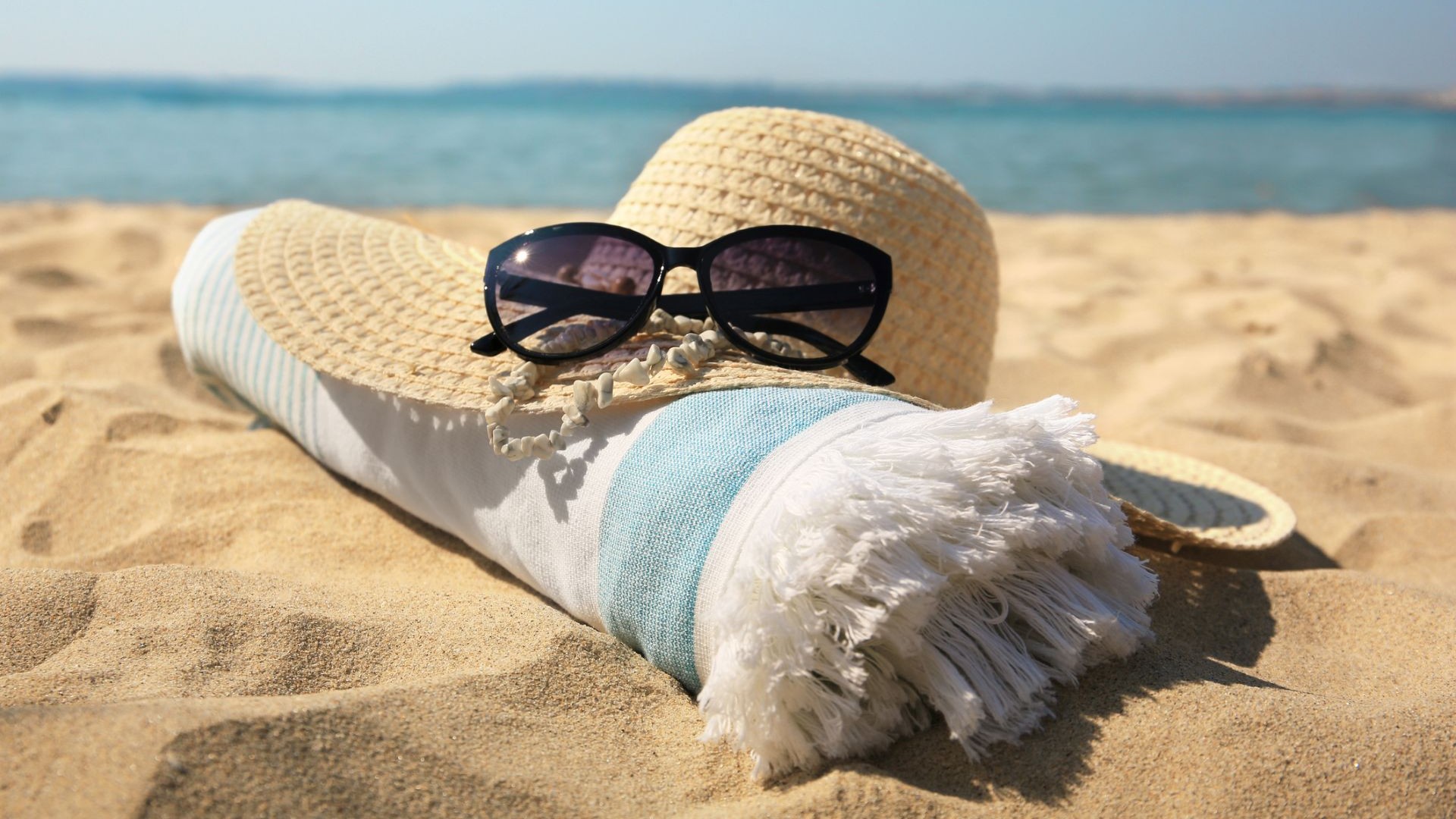 hat sunglasses and towel