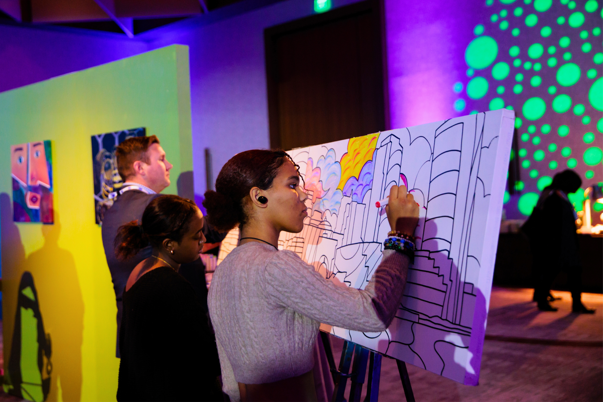 women filling in a canvas with a marker