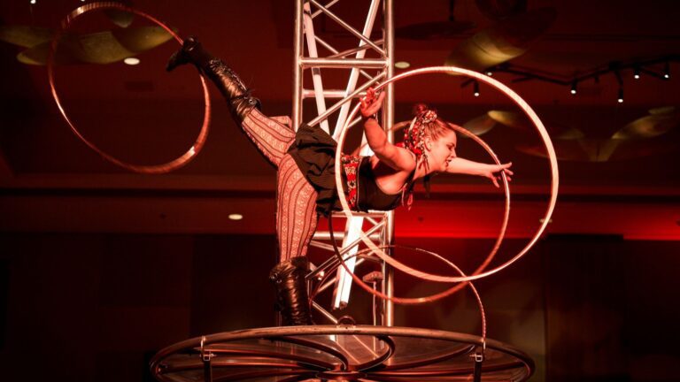 Women balancing on one foot with three hoola hoops